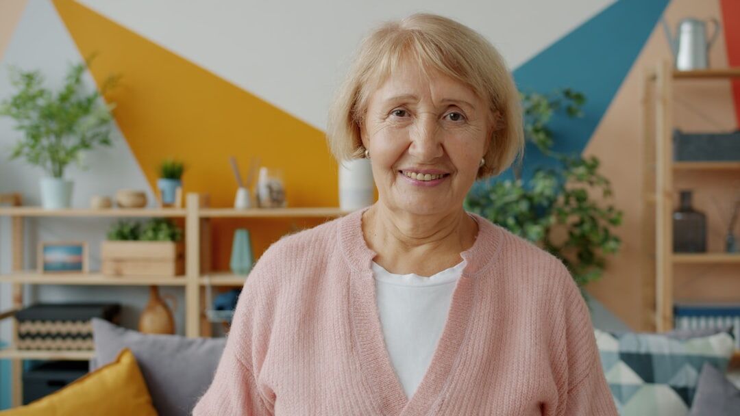Senior woman smiling while using a tablet at home